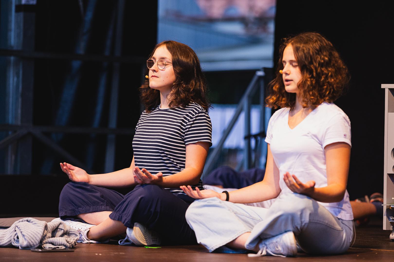 Zwei Jugendliche spielen eine Theaterszene zum Thema Meditation